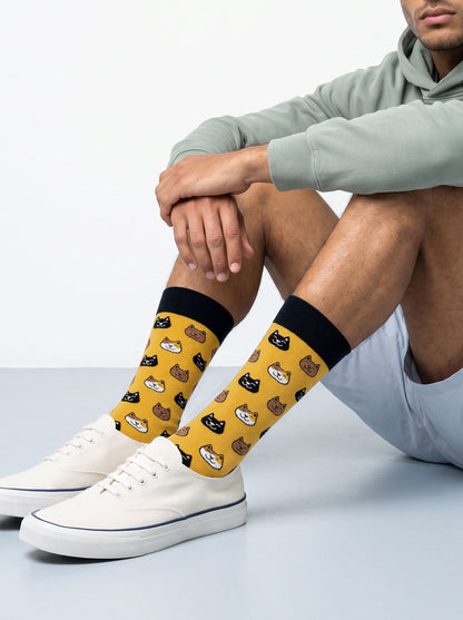 Man wearing yellow cat socks with white trainers