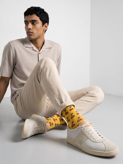 Man in cream trousers wearing yellow cherry socks